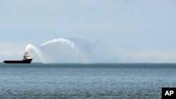 Sebuah kapal tambak menyalakan meriam airnya ke Laut Kaspia di dekat pelabuhan di Baku, Azerbaijan, pada 7 Juni 2021. (Foto: AP/Darko Vojinovic)
