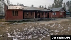 Destroyed books sit in the yard of a partially burned government high school in Goripora, outside of Srinagar, India controlled Kashmir.