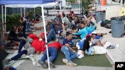 Recently arrived migrants wait in a garage area of the U.S. Customs and Border Protection - Marathon Border Patrol Station, Jan. 4, 2023, in Marathon, Florida.