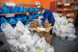 A volunteer prepares bags with groceries for delivery at The Campaign Against Hunger food pantry, Thursday, April 16, 2020, in the Bedford-Stuyvesant neighborhood of the Brooklyn borough of New York.