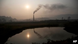 Smoke rises from a brick kiln on the outskirts of Gauhati, India, Jan. 26, 2015.