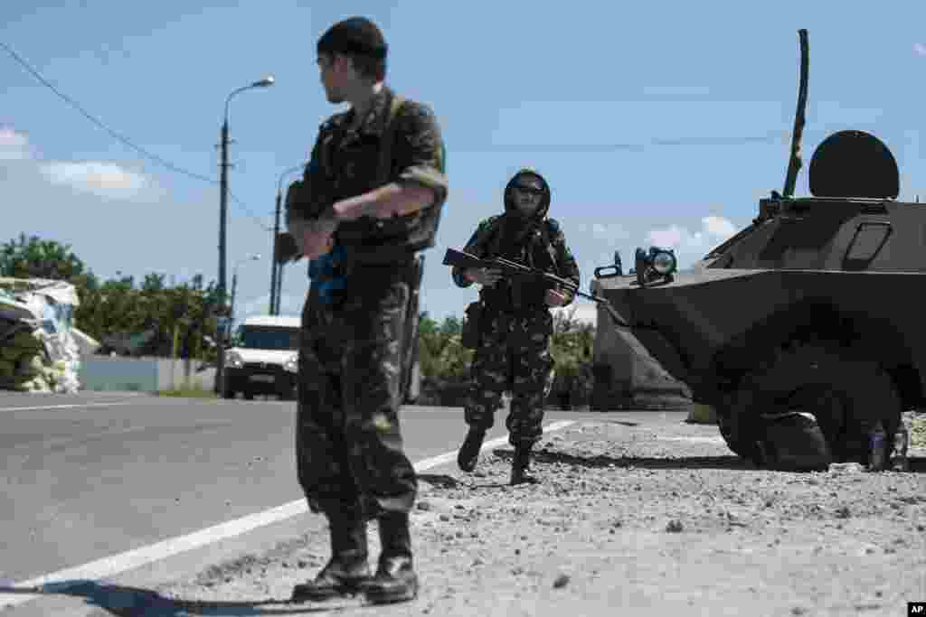 Pro-Russian fighters from a group that calls itself "Russian Orthodox Army" guard at a check point in Donetsk, eastern Ukraine, June 10, 2014.