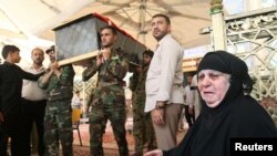 Para pelayat sedang mengusung peti jenazah keluarga mereka yang tewas akibat bom bunuh diri di kawasan pertokoan di Baghdad, Irak.