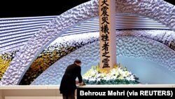 Perdana Menteri Jepang Yoshihide Suga meletakkan bunga di depan altar untuk para korban gempa bumi dan tsunami pada upacara peringatan 10 tahun bencana tersebut, di Tokyo, Jepang 11 Maret 2021. (Foto: Behrouz Mehri via Reuters)