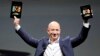Amazon CEO Jeff Bezos holds up the new Kindle Fire HD 7" and Kindle Fire HD 8.9" (L) during Amazon's Kindle Fire event in Santa Monica, California Sep. 6, 2012. 