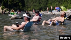 在热浪袭击下的加拿大不列颠哥伦比亚枫树岭，人们坐在艾鲁艾特湖中消暑。(2021年6月28日)