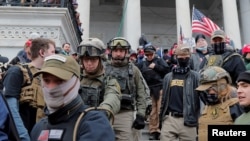 FILE - Jessica Watkins, second from left, and Donovan Crowl, center, both from Ohio, march down the east front steps of the U.S. Capitol with the Oath Keepers militia group among supporters of President Donald Trump in Washington, Jan. 6, 2021.