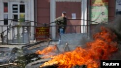A man walks past a burning barricade near the city hall in Mariupol, eastern Ukraine May 10, 2014.