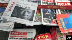 FILE - A front page of a Chinese newspaper with a photo of U.S. President-elect Donald Trump and the headline "Outsider counter attack" is displayed at a newsstand in Beijing, China, Nov. 10, 2016. 