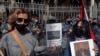 Anti-Hezbollah protesters hold pictures of Lokman Slim, a longtime Shiite political activist and researcher, who was found dead in his car, during a protest in front of the Justice Palace in Beirut, Lebanon, Feb. 4, 2021. 