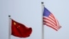 FILE - Chinese and U.S. flags flutter outside a company building in Shanghai, China April 14, 2021.