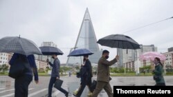 평양 거리에서 행인들이 신종 코로나바이러스 (COVID-19) 감염을 막기 위해 마스크를 쓰고 있다.