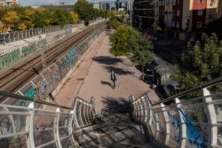A man wearing a face mask to prevent the spread of the coronavirus walks in the southern neighborhood of Vallecas in Madrid, Spain, Oct. 1, 2020.