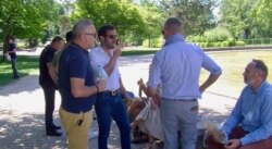 National Rally candidate Julien Odoul, second from left, visits with supporters in Montbeliard. (Lisa Bryant/VOA)