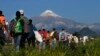 Central American migrants begin their morning trek as part of a thousands-strong caravan hoping to reach the U.S. border, as they face the Pico de Orizaba volcano upon departure from Cordoba, Veracruz state, Mexico, Monday, Nov. 5, 2018.