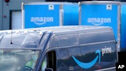 FILE - An Amazon Prime logo appears on the side of a delivery van as it departs an Amazon Warehouse location, Oct. 1, 2020, in Dedham, Massachusetts. 
