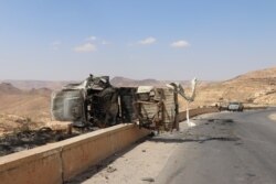 Debris, burnt-out cars and bullet casings remain a day after the battle on the road out of Gharyan, Tripoli. (H.Murdock/VOA)