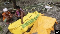 Markus (R) and his sister Lisna cry after they found their mother dead in at Munte village, North Pagai island, West Sumatra, Indonesia, 29 Oct 2010
