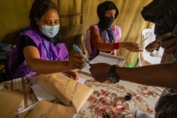 A poll worker marks the finger of an Ethiopian voter in Addis Ababa, Ethiopia, June 21, 2021. (VOA/Yan Boechat)