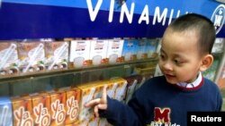 FILE - A Vietnamese boy looks at dairy products at a showroom of the Vietnam Dairy Products Co (Vinamilk) in Hanoi.