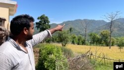 A young Kashmiri pointing toward the Indian army posts on the hilltops lining the de facto Kashmir frontier with Pakistani-administered part of the divided region. (Ayaz Gul/VOA)