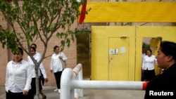 FILE - Ethnic Uyghurs leave a center where political re-education lessons are held in Kashgar, Xinjiang Uyghur Autonomous Region, China, Sept. 6, 2018. The centers are also used for detention.