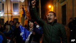 A backer of Bolivia's President Evo Morales shows his support outside the presidential palace in La Paz, Bolivia, after a first round presidential election, Oct. 20, 2019. 