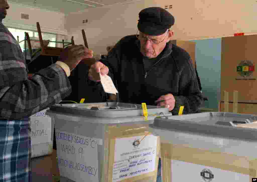 A voter casts his ballot. Zimbabweans flocked to polling stations asts his ballot as the country went to the polls in a Harare suburb.