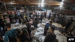 Warga Palestina berkumpul di sekitar mayat-mayat warga Palestina yang tewas dalam serangan di rumah sakit Ahli Arab di Jalur Gaza tengah, setelah mereka diangkut ke rumah sakit Al-Shifa di Jalur Gaza, Selasa nalam 17 Oktober 2023.