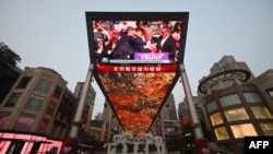 Новина про замах на колишнього президента США Дональда Трампа транслюється у більшості країн світу. На фото - екран у торговому центрі в Пекіні, 14 липня 2024 р. Лідер Китаю Сі Цзіньпін висловив Дональду Трампу співчуття. GREG BAKER/AFP
