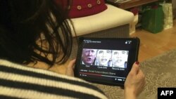 Sesorang melihat video yang dimanipulasi, pada 24 Januari 2019, yang mengubah perkataan mantan presiden Donald Trump dan mantan presiden Barack Obama, yang menggambarkan bagaimana teknologi “deepfake” dapat menipu pemirsa. (Foto: AFP)