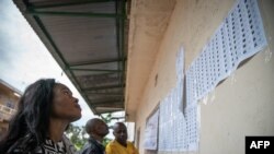ARCHIVES - Une électrice consulte les listes dans un bureau de vote installé au collège Imara de Lubumbashi, dans la province du Haut-Katanga, le 30 décembre 2018.