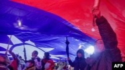 រូបឯកសារ៖ ក្រុមអ្នកគាំទ្រគណបក្ស​ Kuomintang កាន់​ទង់ជាតិ​កោះតៃវ៉ាន់​ក្នុង​ពេល​យុទ្ធនាការ​ឃោសនា​​មួយ​ នៅ​ទីក្រុងតៃប៉ិ កោះតៃវ៉ាន់ កាលពីថ្ងៃទី២៣ ខែធ្នូ ឆ្នាំ២០២៣។ 