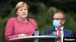 The Major of Templin looks on as German Chancellor Angela Merkel speaks during the 750th city anniversary celebrations in Burgergarten, in Templin, Germany, Sept. 10, 2021.