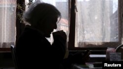 Anna Edith Slepicka, who must stay at home is seen in her house during a coronavirus lockdown in an attempt to slow down the coronavirus disease (COVID-19), in Brussels, Belgium March 31, 2020. (REUTERS/Yves Herman)