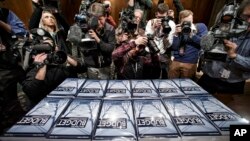 Media photograph copies of President Obama's new $4 trillion budget plan as it arrives on Capitol Hill in Washington, Monday, Feb. 2, 2015. (AP Photo/J. Scott Applewhite)