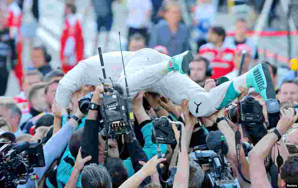 Mercedes F1 driver Nico Rosberg of Germany celebrates a victory with team members after the Russian Grand Prix.