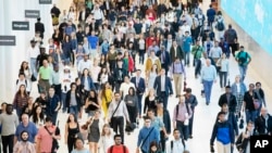 Commuters walk through a corridor in the World Trade Center Transportation Hub, Friday, June 21, 2019 in New York. 