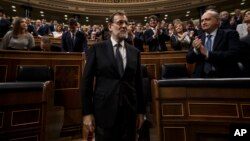 Newly re-elected Spanish Prime Minister Mariano Rajoy, center, is apauded by lawmakers after the second and final confidence vote of the investiture debate at the Spanish Parliament in Madrid, Oct. 29, 2016. 