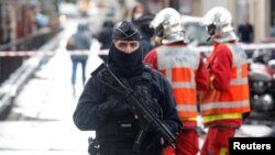 A police officer stands guard at the scene of an incident near the former offices of French magazine Charlie Hebdo, in Paris, Sept. 25, 2020.