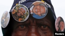 A street vendor sells Nelson Mandela-themed buttons outside the house where the anti-apartheid icon once lived in the township of Soweto, Dec. 9, 2013.