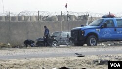 Petugas membersihkan lokasi serangan bom bunuh diri di luar penjara kota Taji, sebelah utara Baghdad (28/11).