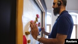 A visually impaired visitor, Farid el Manssouri, touches during the exhibition "The Blind Spot" by artist Jasper Udink ten Cate and experience designer Jeroen Prins, aimed for blind and visually impaired visitors to appreciate art by touching and smelling
