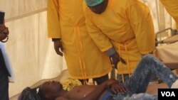 Zimbabwe President Emmerson Mnangagwa talks to one of the cholera victims on Sept. 19, 2018 in Glen View’s Harare, epicenter of the waterborne disease. (C. Mavhunga/VOA)