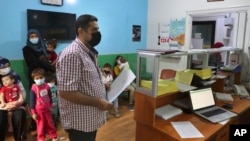Hassan Taha, who suffers from a heart condition, seeks medication from the Amel Association, a Lebanese humanitarian group, in Dahiyeh, a southern suburb of Beirut, Lebanon, Tuesday, Nov. 3, 2020. (AP Photo/Bilal Hussein)