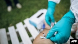 រូបឯកសារ៖ មន្រ្តីផ្នែកសុខាភិបាលម្នាក់យកសំណាកឈាមពីមនុស្សម្នាក់មកធ្វើតេស្តរកជំងឺកូវីដ ១៩ នៅសាធារណរដ្ឋប្រជាធិបតេយ្យកុងហ្គោ កាលពីថ្ងៃទី៣១ ខែមីនា ឆ្នាំ២០២០។