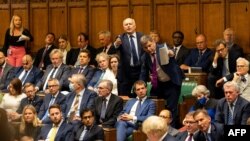 A handout photograph released by the UK Parliament shows parliamentarians reacting to Prime Minister Boris Johnson (bottom) during an extraordinary session to discuss the collapse of the Afghan government, Aug. 18, 2021. (Roger Harris/ UK Parliament/AFP)