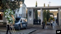 People carry wreaths at Mingorrubio's cemetery, on the outskirts of Madrid, Spain, Oct. 24, 2019. Forty-four years after his death, the remains of Spanish dictator Gen. Francisco were exhumed from his resting place and taken to a small family crypt.