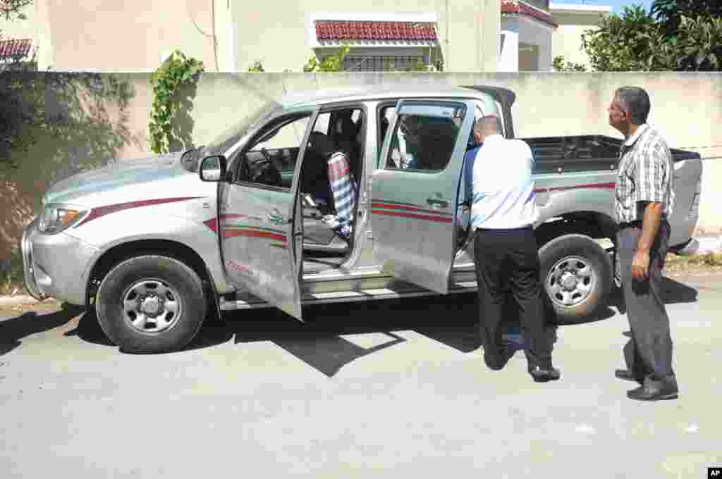 Tunisian police officers inspect Mohamed Brahmi&#39;s vehicle in which he was shot to death, outside his home in Tunis, July 25, 2013.&nbsp;