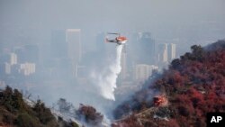 Sebuah helikopter menyiramkan air untuk memadamkan api kebakaran yang dijuluki "Getty Fire" yang menghanguskan kawasan Kenter Canyon di Los Angeles, California, 28 Oktober 2019. 